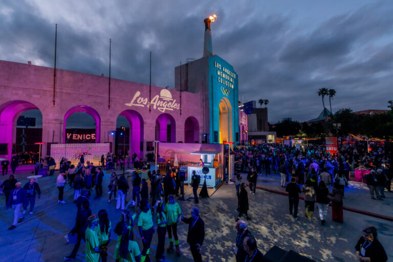 Stormtrooper-costumed performers gather outside the Los Angeles Memorial Coliseum beneath its illuminated tower.