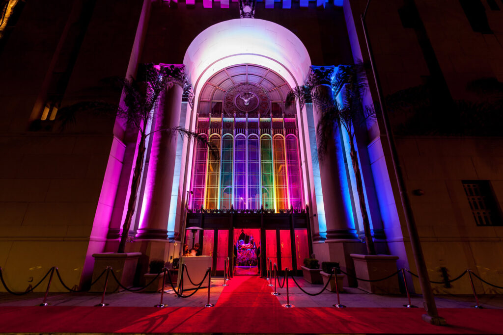 A red carpet leads beneath a rainbow-lit arch at the Google Holiday Party.