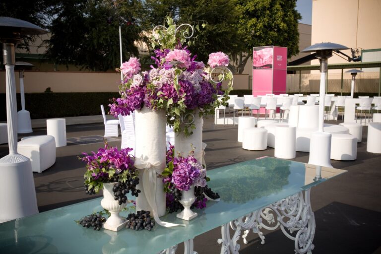 Pink floral arrangement in foreground with a Wolfmother stage sign visible in the background at a brand activation, photographed in Los Angeles.