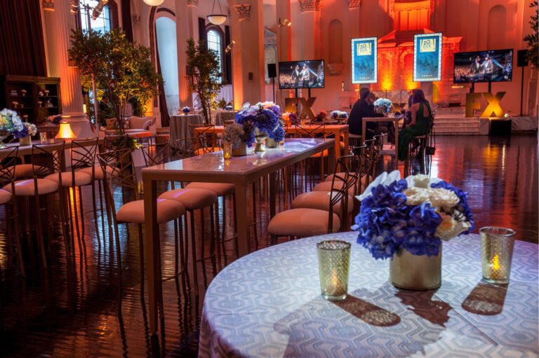 Empty classical ballroom with a FOX, FX Networks, National Geographic Channel, and 59th Emmy Awards branded step-and-repeat backdrop and warm stage lighting, photographed in Los Angeles.