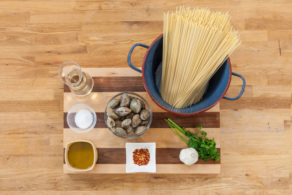 Overhead food-styling arrangement with a central bowl, serving pieces and small dishes on a wooden table.