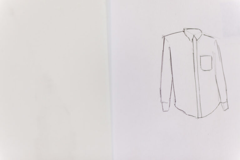 Line drawing of a long-sleeved button-front shirt on a white sheet of paper.