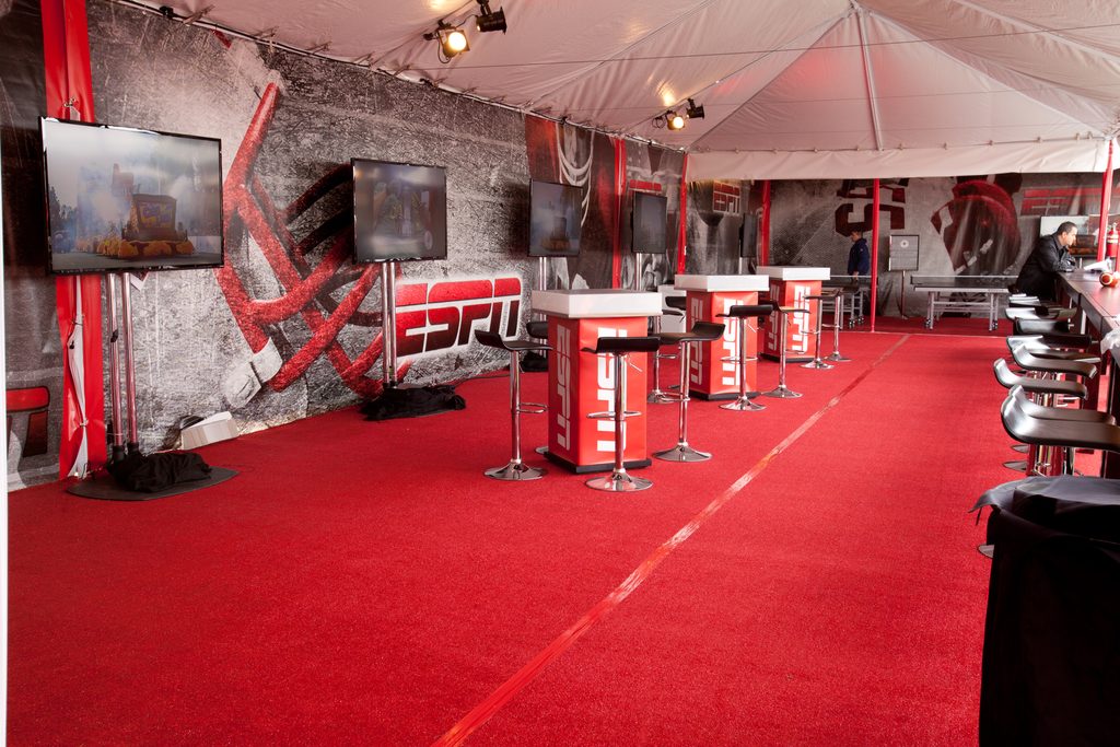 ESPN VIP hospitality lounge at the Rose Bowl in Pasadena, featuring red carpeting, branded cocktail tables, bar seating, television displays and custom corporate event décor.